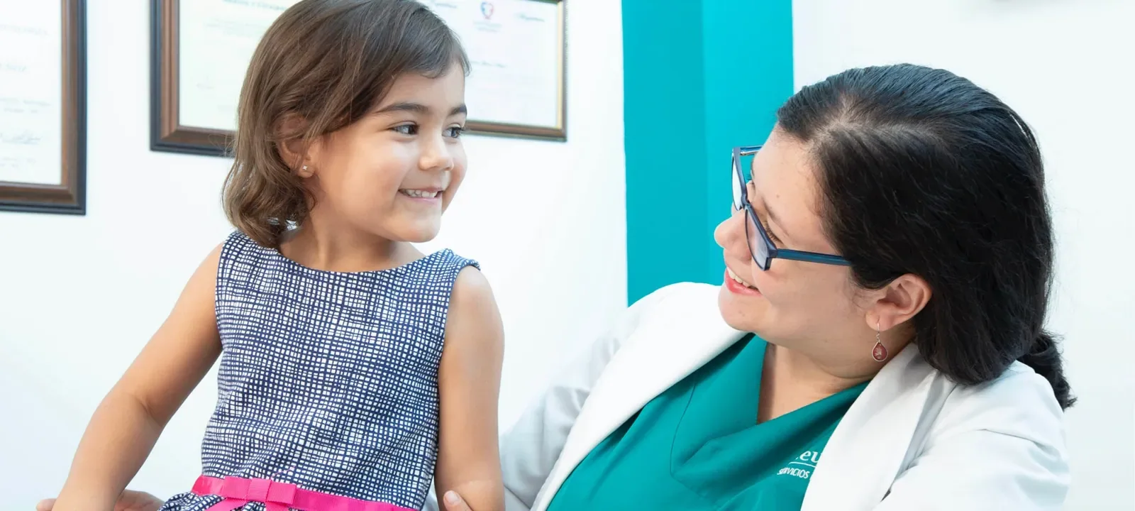 Neuropsicóloga sonriendo a una niña durante una consulta en el centro Neuropser de Medellín